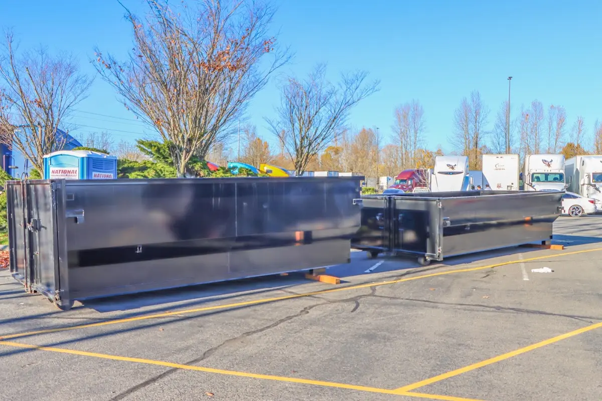 Professional dumpster rental service with roll-off container on residential driveway in Pittston